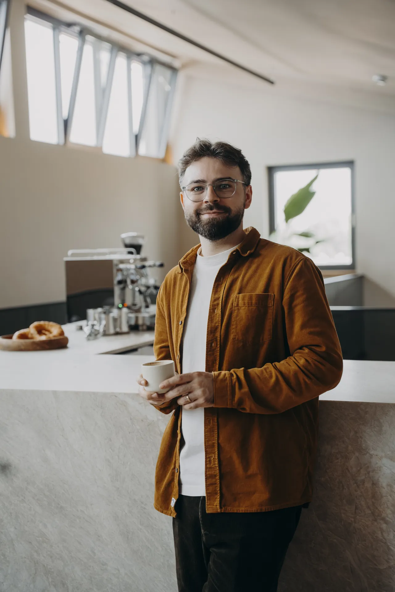 Marlon Marquart am Tresen, mit einer Tasse Kaffee