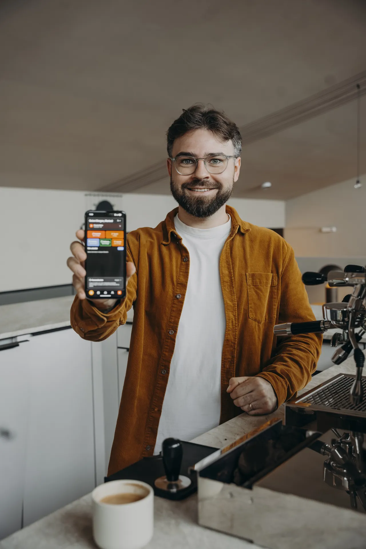 Marlon Marquart zeigt die Gastro Cockpit App auf dem Handy